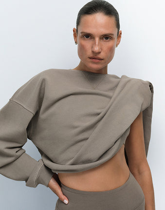 MATE model wearing a heather grey organic pointelle wrap-style top and matching pants, hand on hip against a light background