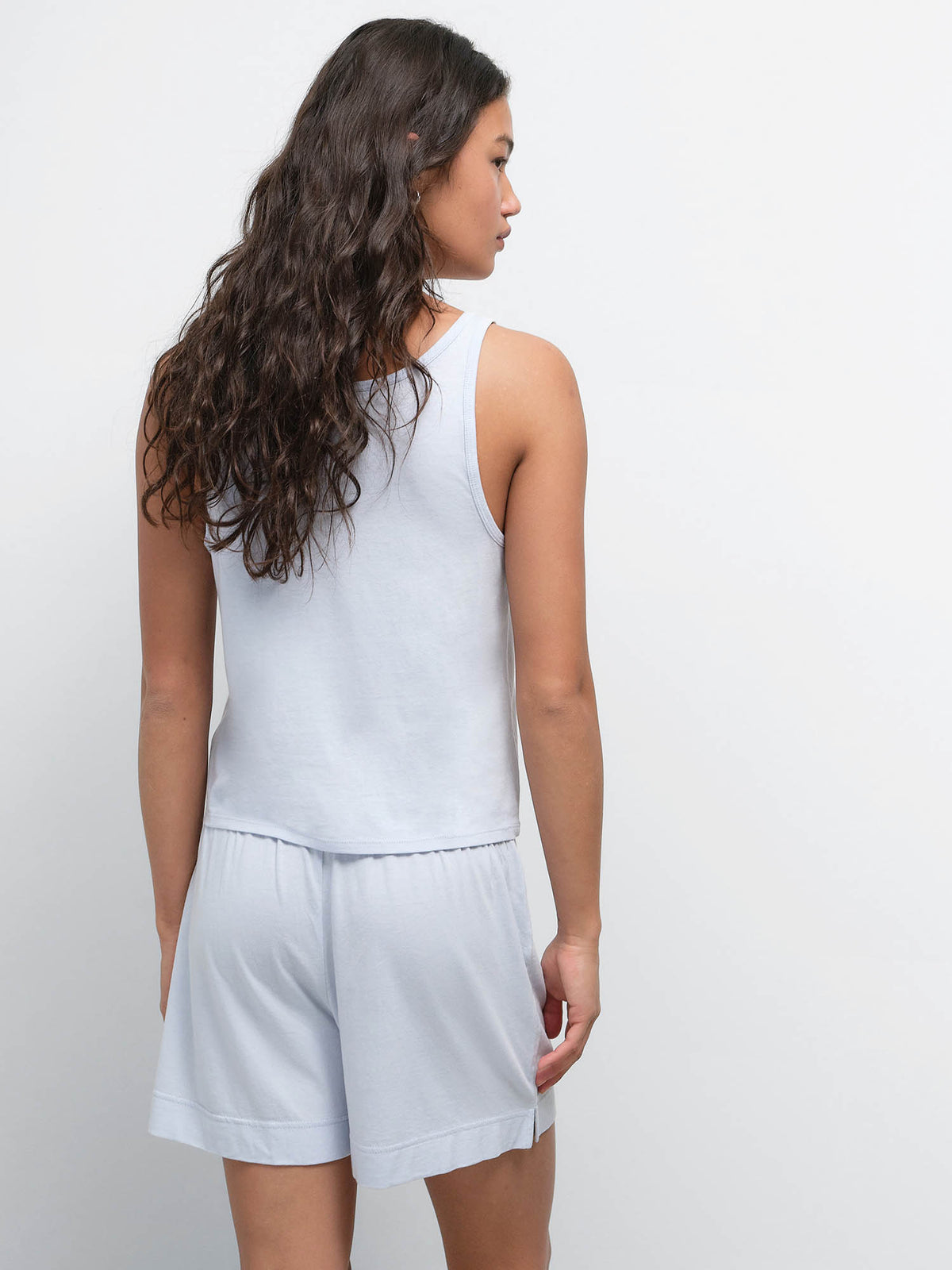 Back view of model with long dark hair wearing the Tencel Sleep Scoop Tank and Boxer Short in Powder