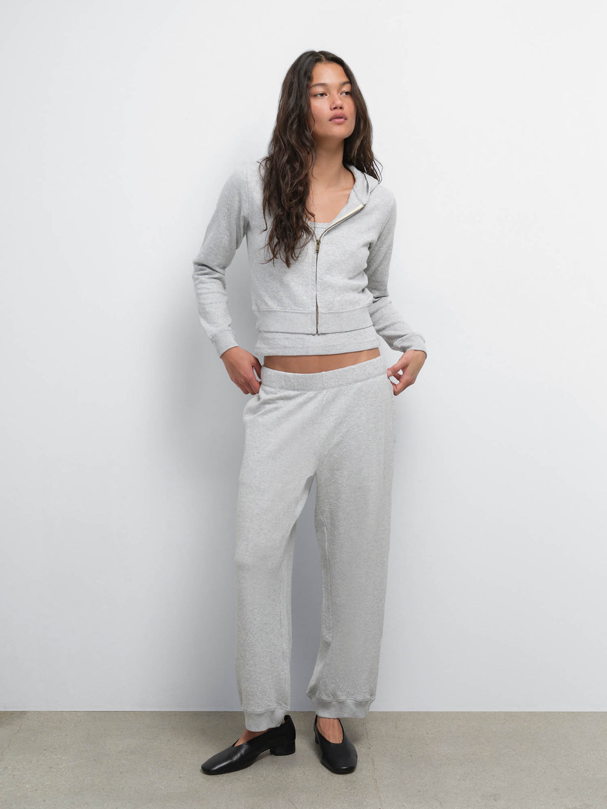 Full-length view of model with hands in pockets in the Organic Pointelle Shrunken Hoodie and Jogger in Heather Grey