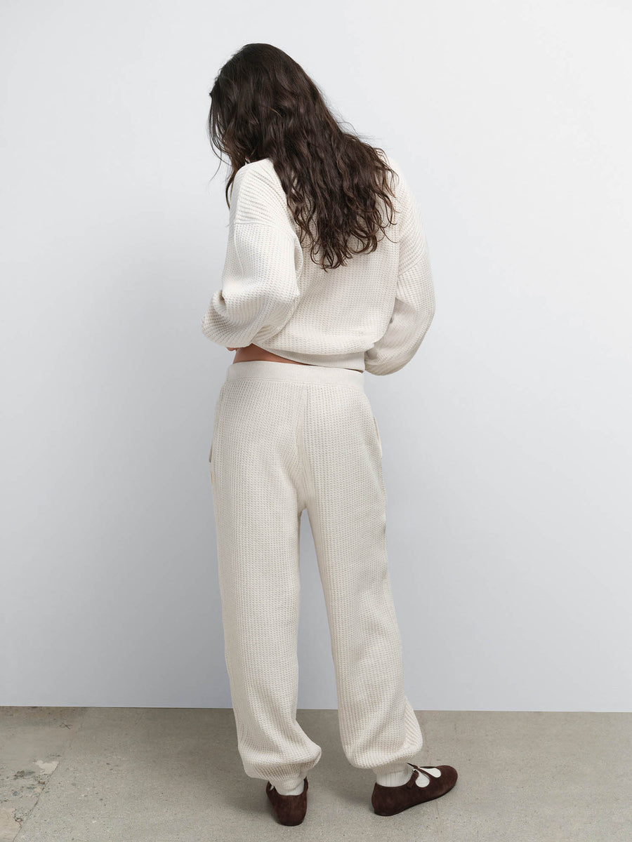 Back view of model wearing the Organic Waffle Crewneck Sweatshirt and Sweatpant in Oat