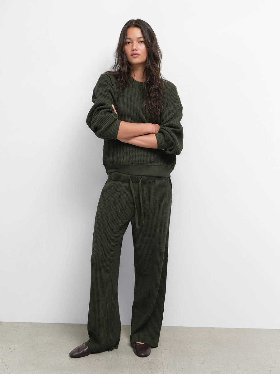Model standing with arms crossed in the Organic Waffle Crewneck Sweatshirt and Straight Leg Sweatpant in Heather Pine