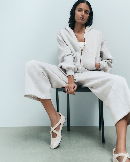 Model in an oatmeal organic zip-up hoodie and wide-leg pants – shop MATE the Label intimates and loungewear