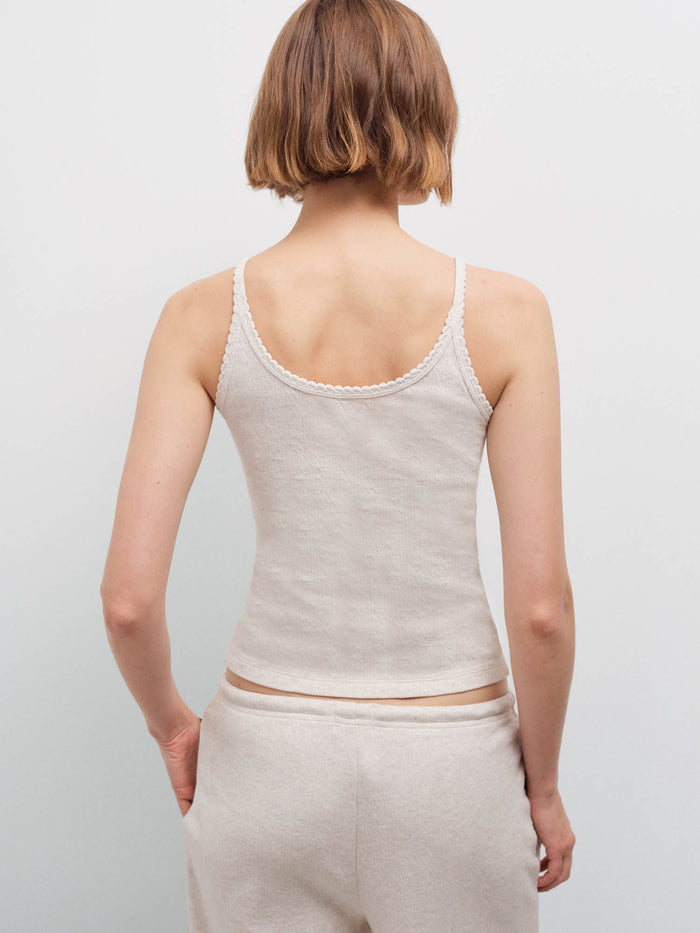 Woman wearing an oatmeal ribbed camisole and matching sweatpants, back view in studio
