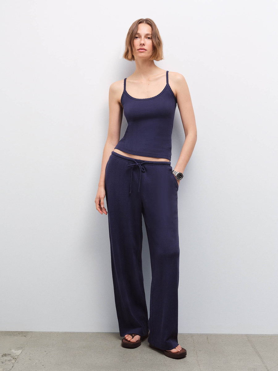 Woman wearing navy pointelle tank and matching wide-leg pants, full-length front view in studio