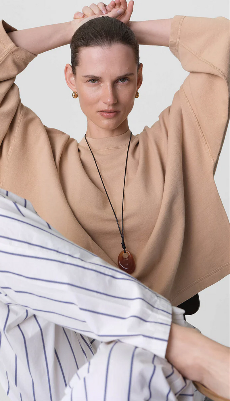 model in a sienna lightweight terry sweatshirt and striped poplin pants