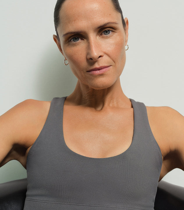 Portrait of a model wearing a gray tank top with hoop earrings