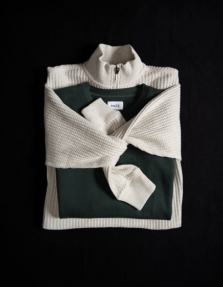 Cream half-zip pullover folded over a dark green top – MATE the Label