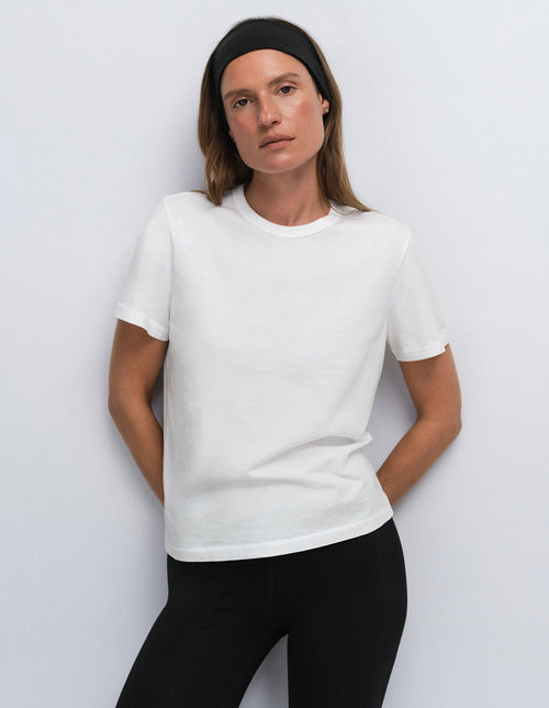 Model wearing a white classic t-shirt and black leggings with a black headband, Mate the Label