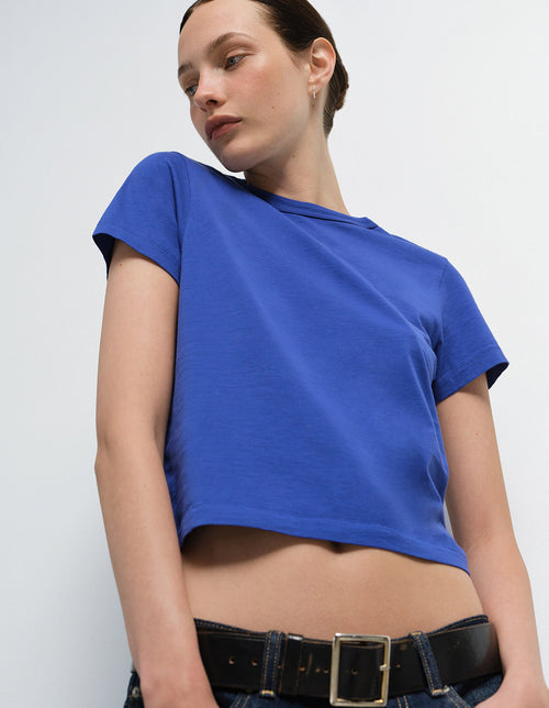 Model wearing a blue cropped t-shirt and jeans, Mate the Label