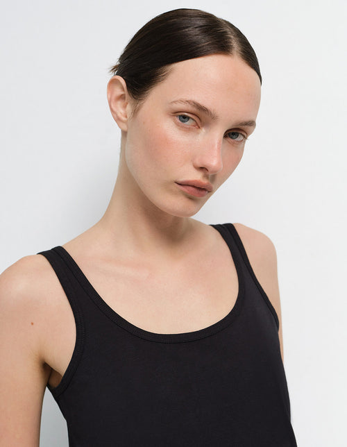 Close-up of a model wearing a black tank top from Mate the Label